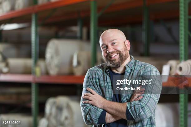 mature man working in carpet warehouse - roll shirt stock pictures, royalty-free photos & images