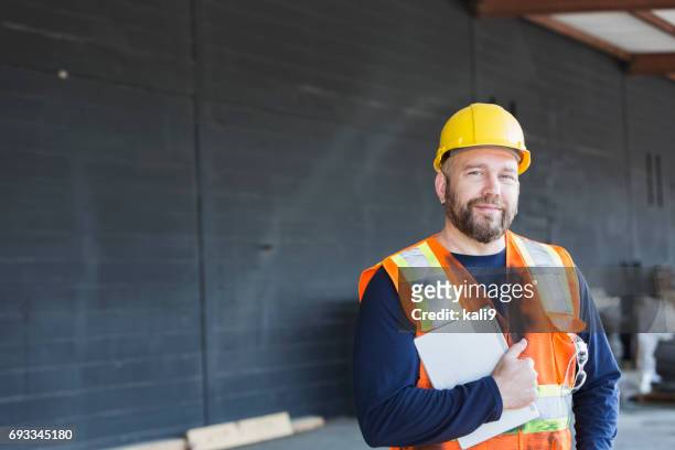 arbetaren i säkerhetsväst och hardhat holding digital tablett - byggarbetare bildbanksfoton och bilder
