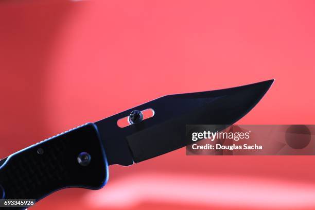 hunting knife silhouette on a red background - table knife stockfoto's en -beelden