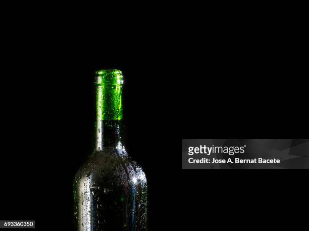 wine bottle of beer with the frosted glass with drops of water and a steam cloud frozen on a black bottom - beer mat stockfoto's en -beelden
