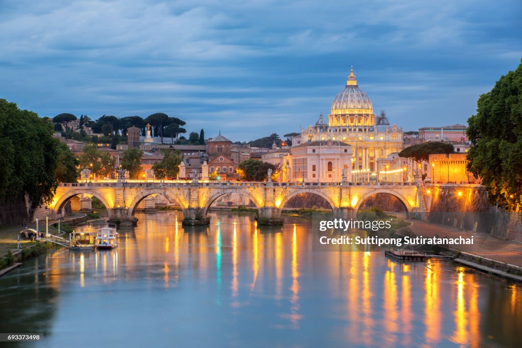Sunset view of St. Peters Basilica in the Vatican and the Ponte Sant'Angelo, Bridge of Angels, at the Castel Sant'Angelo and river Tiber in Rome, Italy