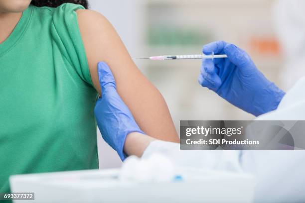 unrecognizable girl receives flu shot - pharmacy vaccination stock pictures, royalty-free photos & images