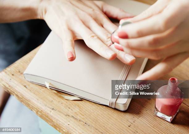 close up hands of an adult woman doing manicure at home - esmalte cosmético - fotografias e filmes do acervo