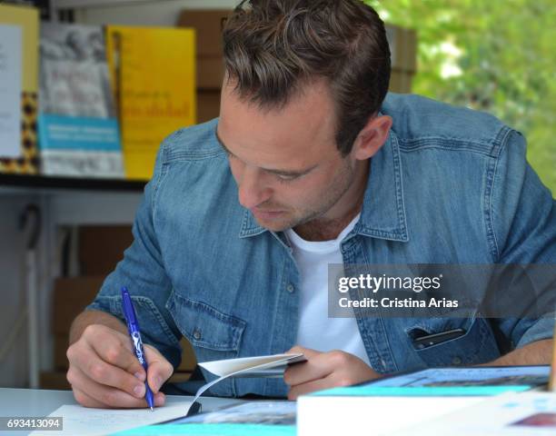 The swiss writer Joel Dicker signs a book during the Book Fair 2017 at El Retiro Park on June 3, 2017 in Madrid, Spain.