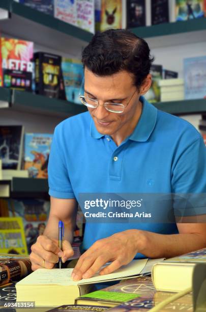 The writer Marcos Chicot signs a book during the Book Fair 2017 at El Retiro Park on June 3, 2017 in Madrid, Spain.