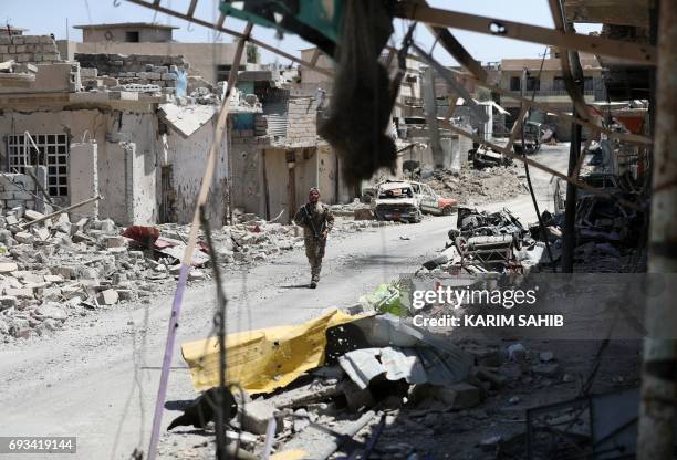 Member of the Iraqi government forces advances in western Mosul's Zanjili neighbourhood on June 7 during ongoing battles as they try to retake the...