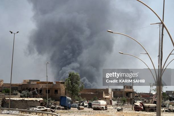 Smoke billows from buildings following an explosion in western Mosul's Zanjili neighbourhood on June 7 during ongoing battles as Iraqi forces try to...