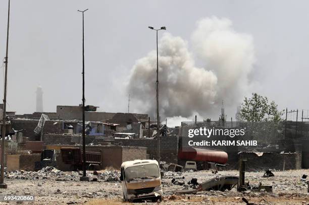 Smoke billows from buildings following an explosion in western Mosul's Zanjili neighbourhood on June 7 during ongoing battles as Iraqi forces try to...