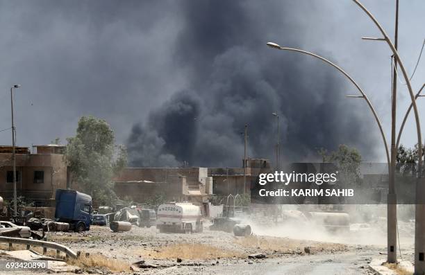 Smoke billows from buildings following an explosion in western Mosul's Zanjili neighbourhood on June 7 during ongoing battles as Iraqi forces try to...