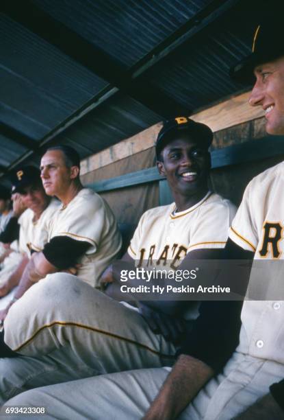 Roberto Clemente of the Pittsburgh Pirates smiles as he sits in the dugout during an MLB Spring Training game on March 7, 1957 at Terry Park in Fort...