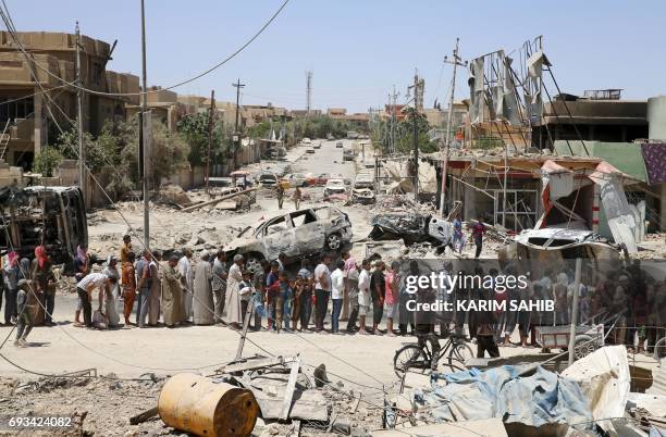 Iraqis stand in line to receive food aid in western Mosul's Zanjili neighbourhood on June 7 during ongoing battles as Iraqi forces try to retake the...