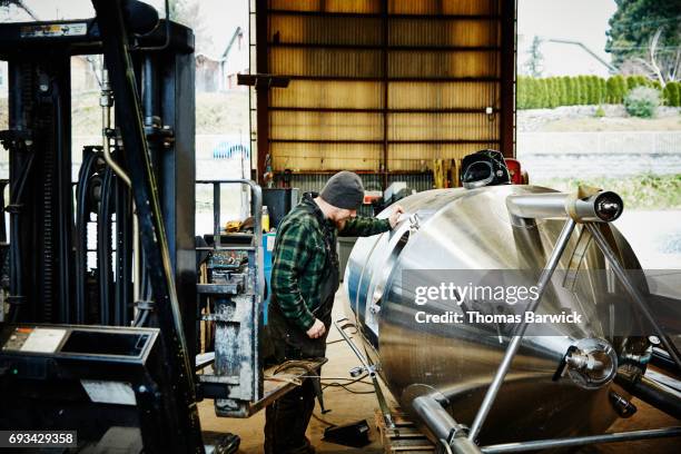 man looking inside stainless steel tank before beginning weld project in metal workshop - thinktank stock pictures, royalty-free photos & images