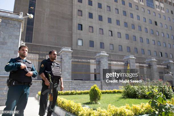 Police officers stand outside Iran's parliament building following an attack by several gunmen on June 7, 2017 in Tehran, Iran. At least 12 people...