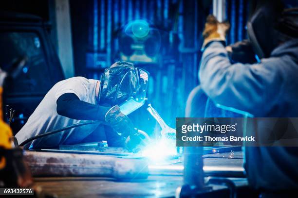 welder welding frame in metal shop - metaalindustrie stockfoto's en -beelden