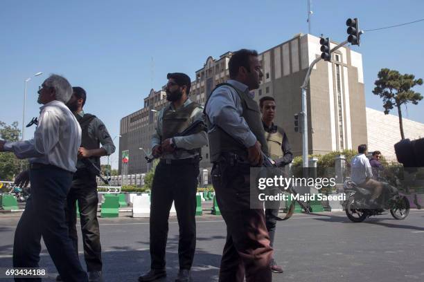 Police officers stand outside Iran's parliament building following an attack by several gunmen on June 7, 2017 in Tehran, Iran. At least 12 people...