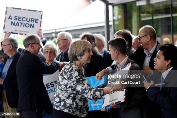 Prime Minister Theresa May greets supporters with her husband Philip as she arrives for her last campaign visit at the National Conference Centre on...