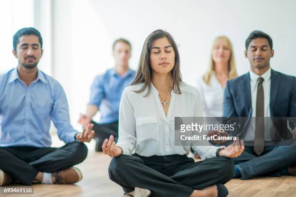 meditating at the office - meditação imagens e fotografias de stock
