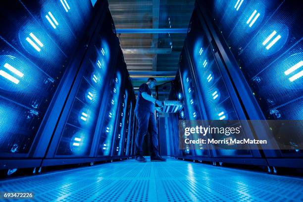 An employee of the German Climate Computing Center poses next to the "Mistral" supercomputer, installed in 2016, at the German Climate Computing...