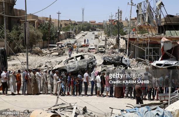 Iraqis stand in line to receive food aid in western Mosul's Zanjili neighbourhood on June 7 during ongoing battles as Iraqi forces try to retake the...