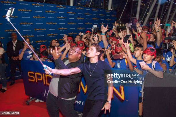 Actors Tom Holland and Jacob Batalon pose for a selfie with fans during the "Spider-Man: Homecoming" event at Marina Bay Sands on June 6, 2017 in...