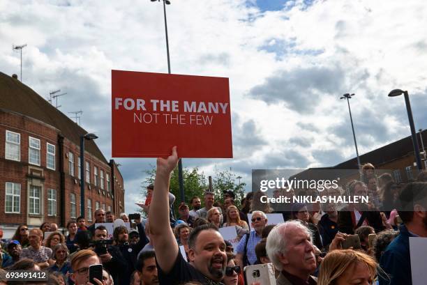 Supporter of Britain's opposition Labour Party leader Jeremy Corbyn holds a sign during a general election campaign rally in Watford on June 7, 2017...