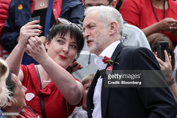 Jeremy Corbyn, leader of the U.K. Opposition Labour Party, right, poses for a selfie photograph with an attendee during a general-election campaign...