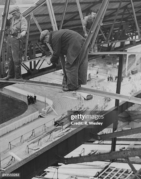 Girder men working on the roof of the new East Stand development at Tottenham Hotspur's White Hart Lane ground, London, 17th July 1934.
