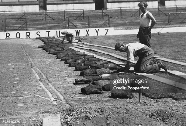 Workmen laying new turf on the pitch at Tottenham Hotspur's White Hart Lane ground, London, 1952.
