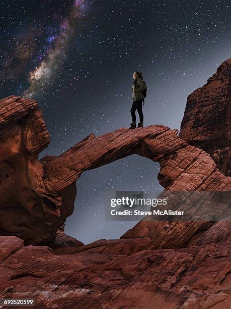 woman standing on rock arch viewing milky way - valley of fire state park stock pictures, royalty-free photos & images