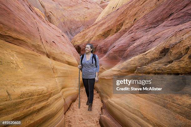 woman hiking in slot canyon, valley of fire state - valley of fire state park stock pictures, royalty-free photos & images