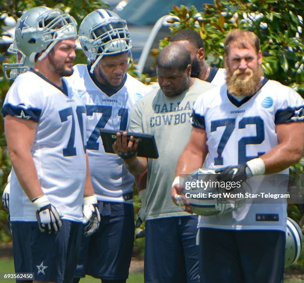 Dallas Cowboys offensive linemen Zack Martin , La'el Collins and Travis Frederick review plays during the team's OTA practice at The Star in Frisco,...