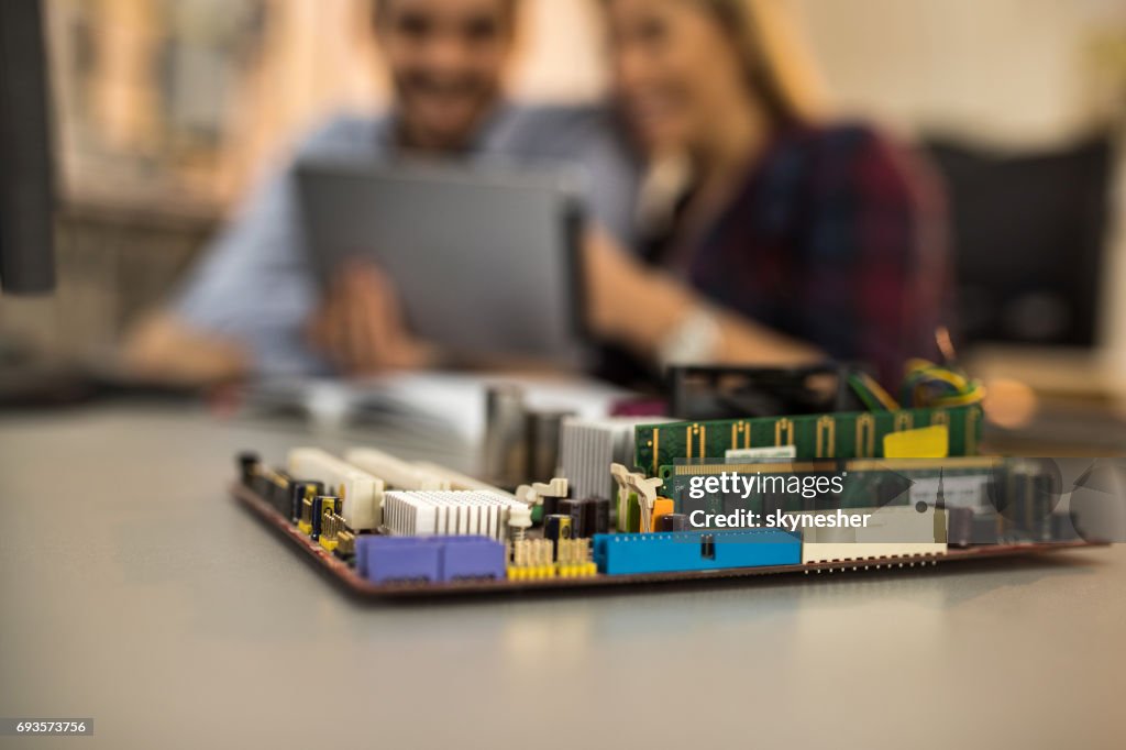 Close up of mother board with people in the background.