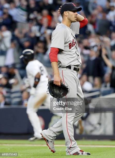 Rick Porcello of the Boston Red Sox reacs as Chris Carter of the New York Yankees rounds first base after Carter hit a three run home run in the...