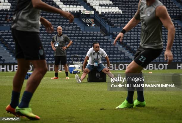 This photo taken on May 17, 2017 shows 58-year-old former Thai MP, Newin Chidchob , watching Buriram United football players warm up before a Thai...