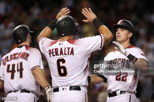 Jake Lamb of the Arizona Diamondbacks high fives Paul Goldschmidt and David Peralta after hitting a two-run home run against the San Diego Padres...