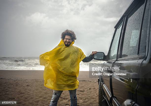 man on the beach on rainy day - regen auto stock-fotos und bilder