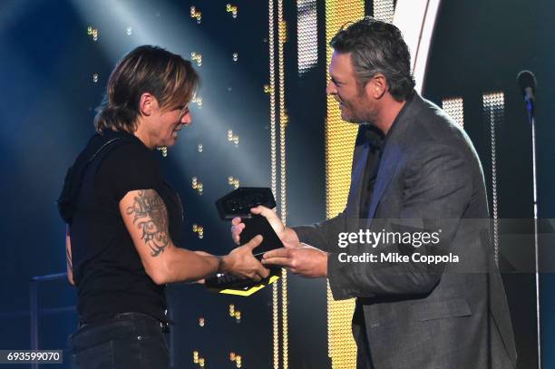 Keith Urban receives Best Male Video of the Year award from Blake Shelton onstage during the 2017 CMT Music Awards at the Music City Center on June...