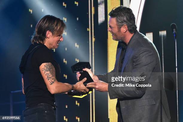 Keith Urban accepts award from Blake Shelton onstage during the 2017 CMT Music Awards at the Music City Center on June 6, 2017 in Nashville,...