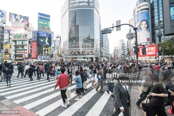 famous crowdy shibuya crossing in tokyo, japan, during the day in may 2017 - shibuya crossing stock pictures, royalty-free photos & images