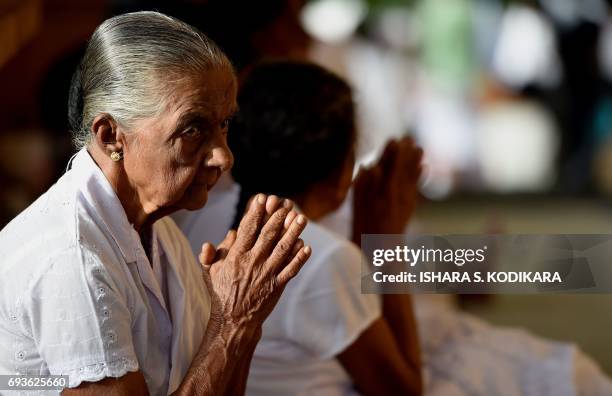 Sri Lankan Buddhist devotee offers prayers at the Kelaniya Temple during the Poson festival in the Colombo suburb of Kelaniya on June 8, 2017. Sri...