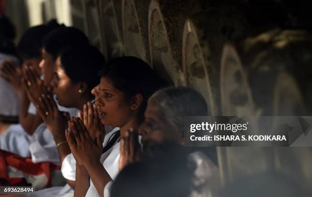 Sri Lankan Buddhist devotees offer prayers at Kelaniya Temple during the Poson Festival in the Colombo suburb of Kelaniya on June 8, 2017. Sri Lanka...