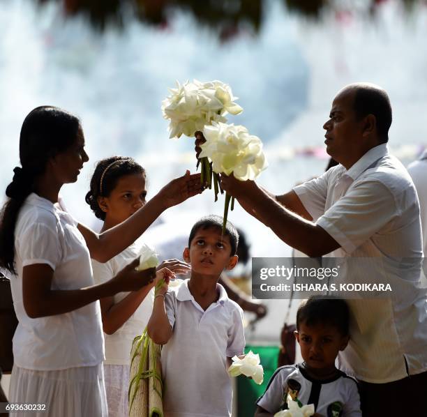 Sri Lankan Buddhist devotees visit Kelaniya Temple to mark the Poson Festival in the Colombo suburb of Kelaniya on June 8, 2017. Sri Lanka celebrates...