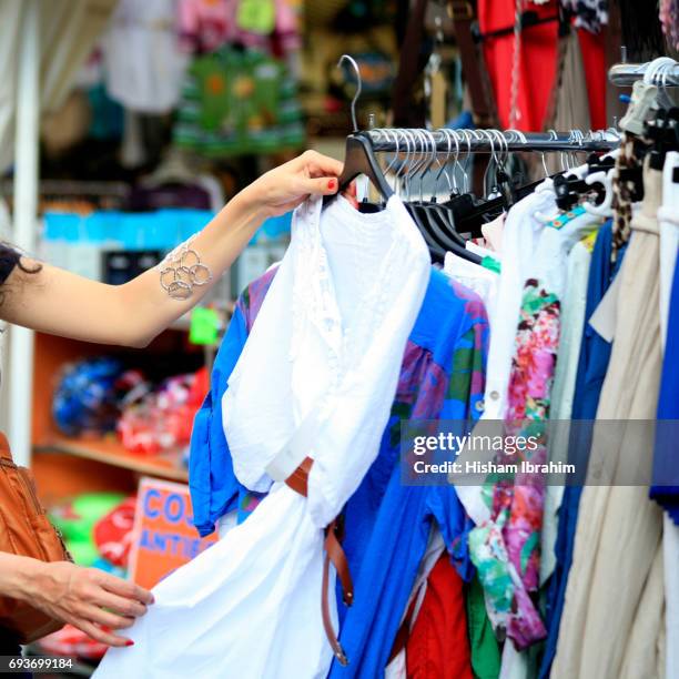 woman shopping for clothing at "el rastro" flea market, madrid,, spain - el rastro stockfoto's en -beelden