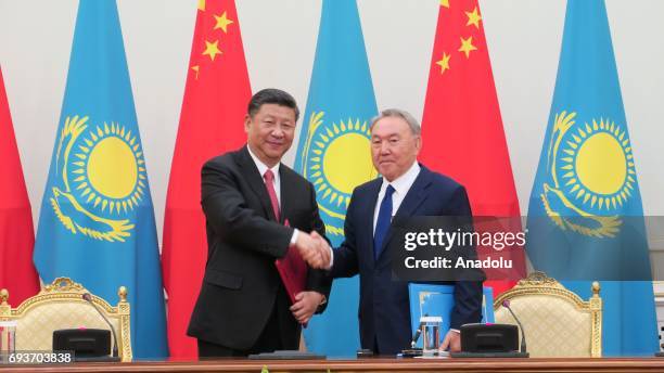 Chinese President Xi Jinping shakes hands with Kazakhstan's President Nursultan Nazarbayev during their meeting on economic, investment, culture,...