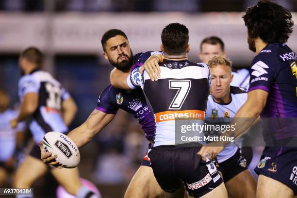 Jesse Bromwich of the Storm offloads the ball in a tackle during the round 14 NRL match between the Cronulla Sharks and the Melbourne Storm at...