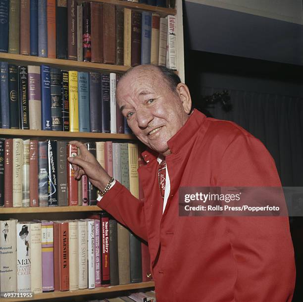 English actor, playwright and director, Noel Coward pictured in his library at home in the village of Les Avants near Montreux, Switzerland in...