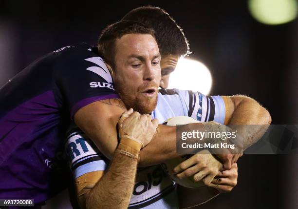 James Maloney of the Sharks is tackled during the round 14 NRL match between the Cronulla Sharks and the Melbourne Storm at Southern Cross Group...