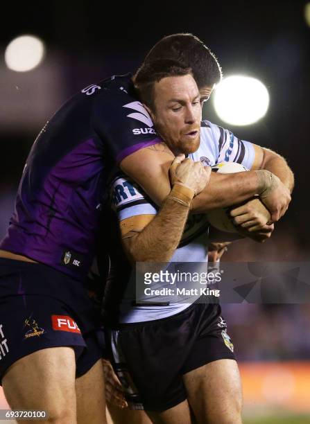 James Maloney of the Sharks is tackled during the round 14 NRL match between the Cronulla Sharks and the Melbourne Storm at Southern Cross Group...