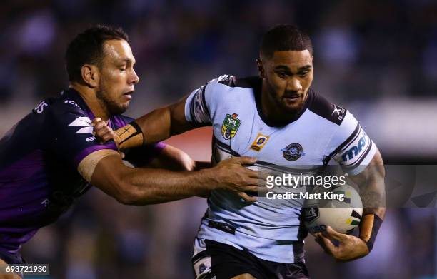 Ricky Leutele of the Sharks is tackled by Will Chambers of the Storm during the round 14 NRL match between the Cronulla Sharks and the Melbourne...