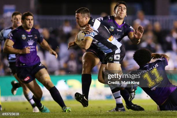 James Maloney of the Sharks is tackled during the round 14 NRL match between the Cronulla Sharks and the Melbourne Storm at Southern Cross Group...